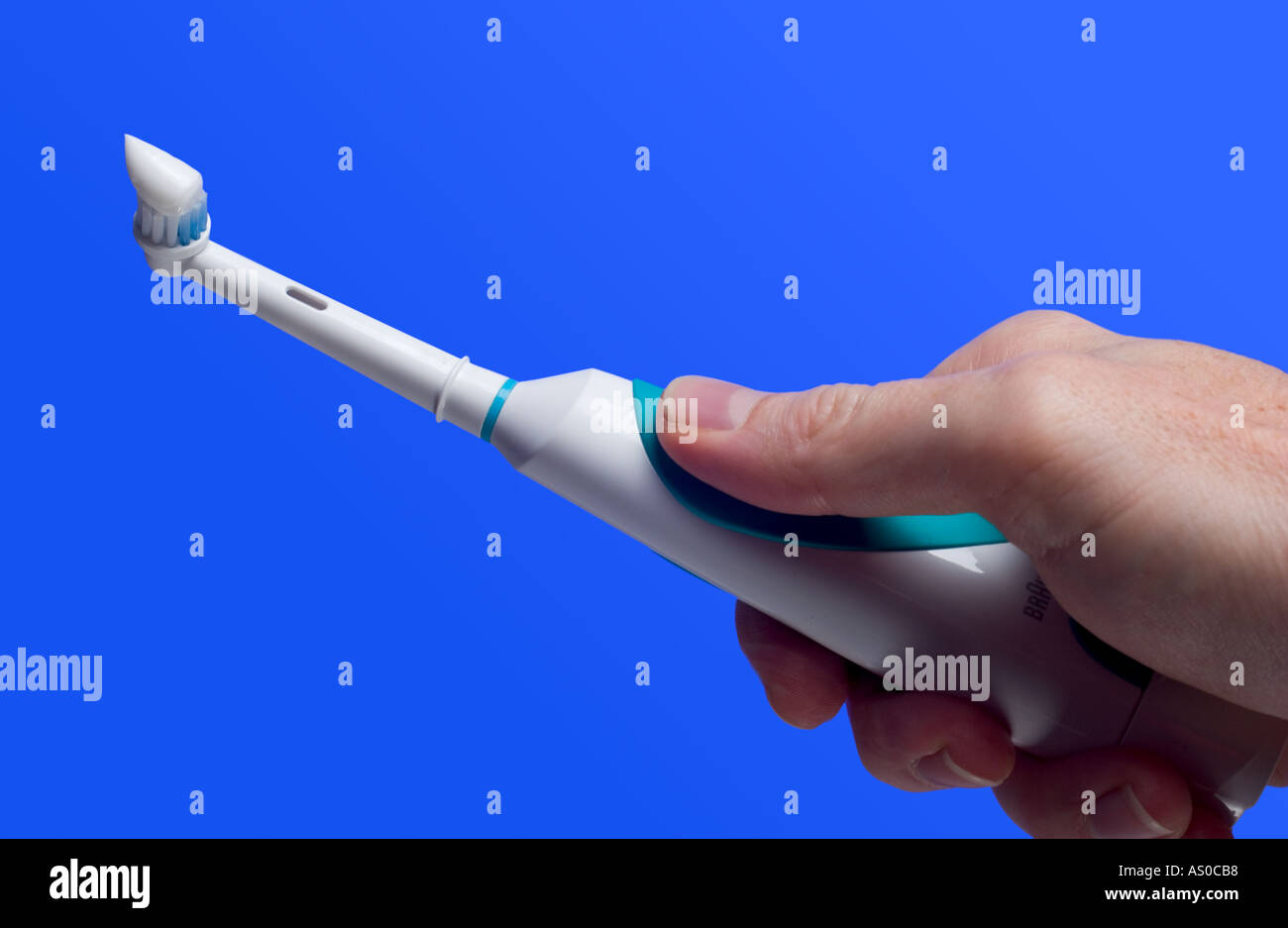 electric toothbrush with toothpaste. Close up of a mans hand holding ...