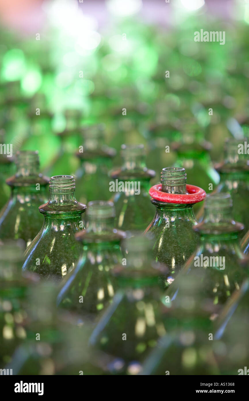 Rows of transparent green bottles with one winning red ring resting on the neck of one bottle at an amusement midway Stock Photo