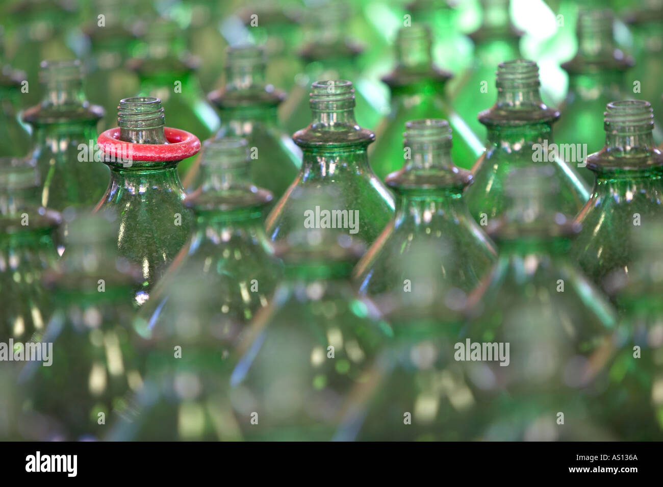 Rows of transparent green bottles with one winning red ring resting on the neck of one bottle at an amusement midway Stock Photo