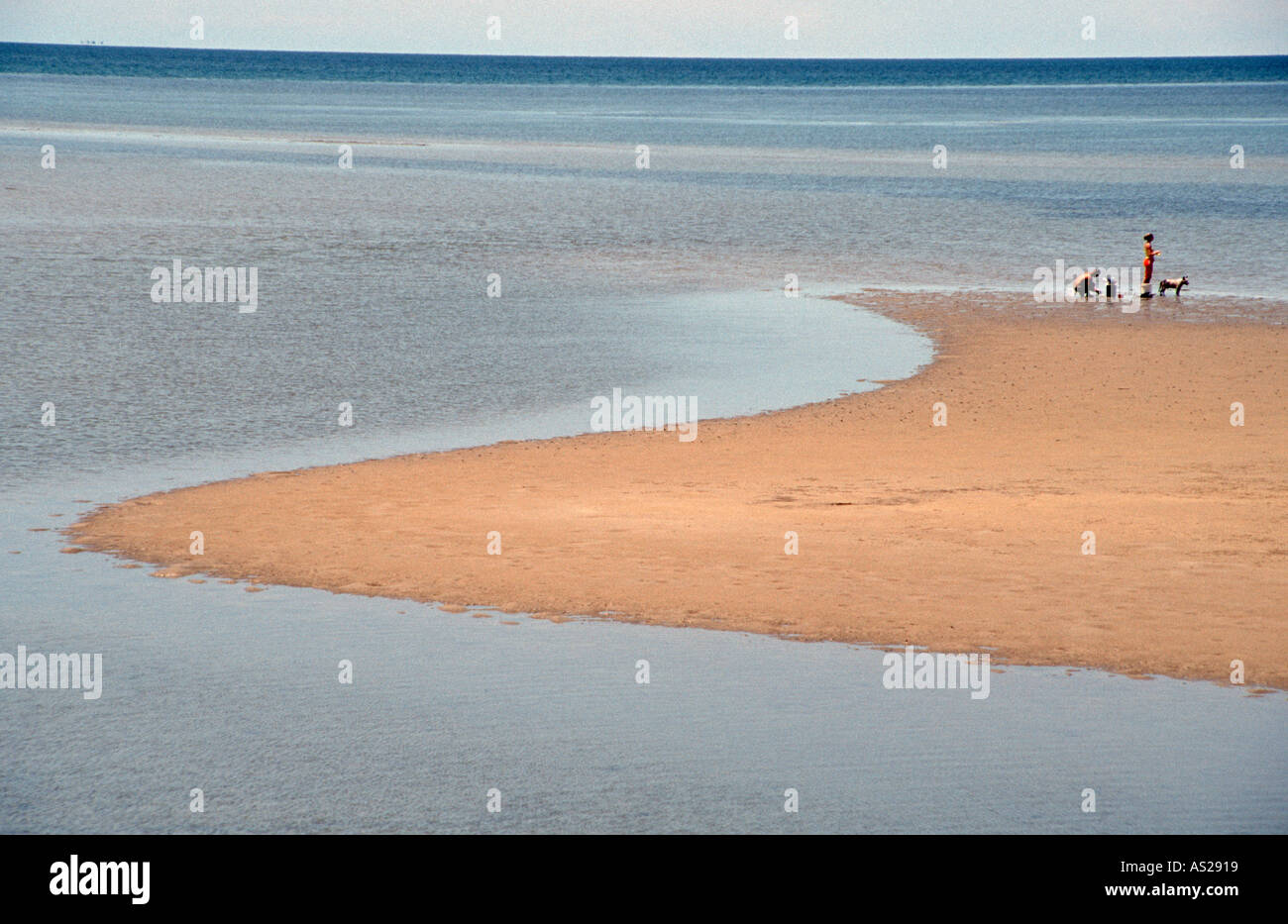 Isolated golden sandy beach azure blue sea with family Yule Point Australia Stock Photo