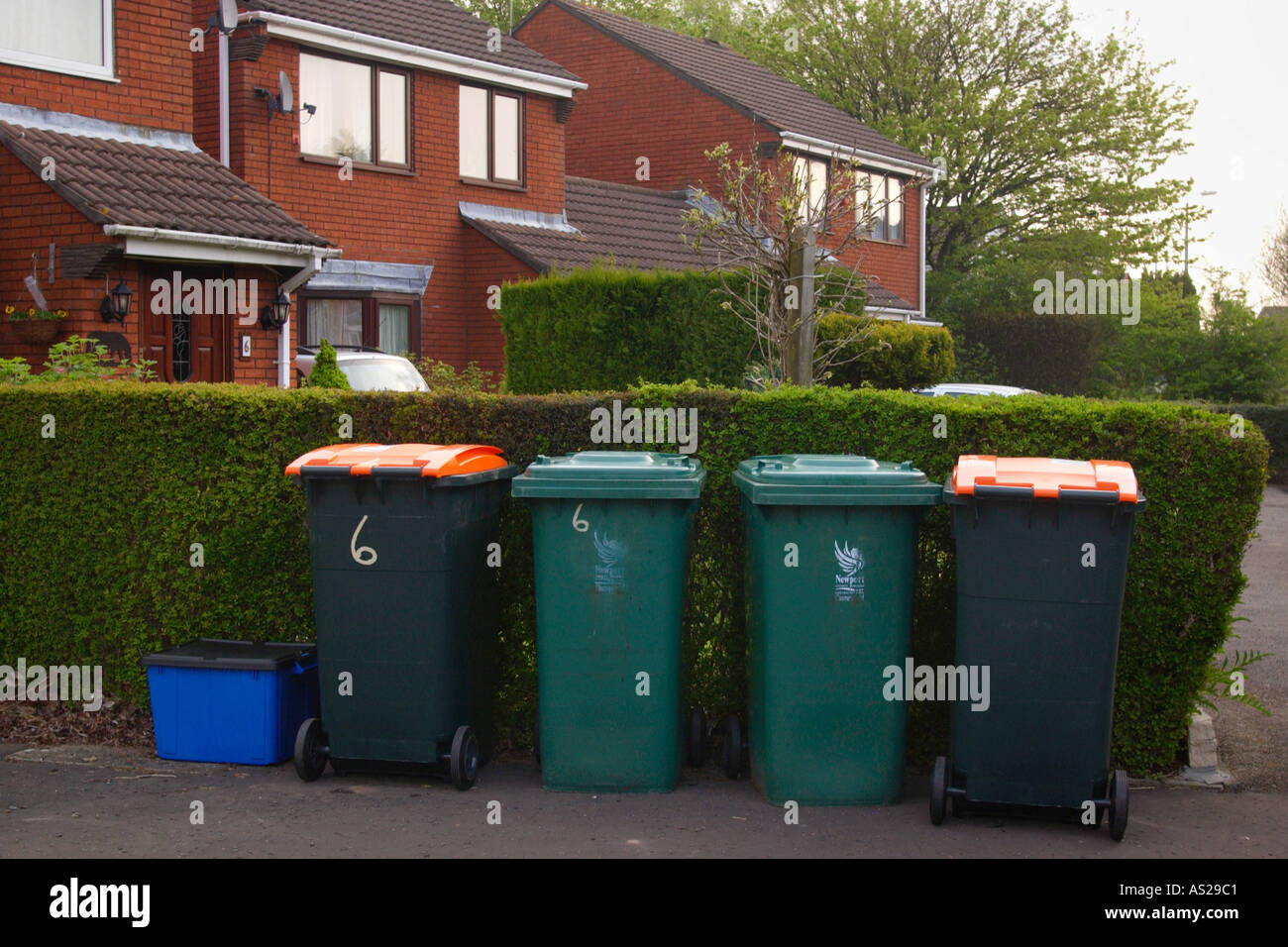 Boxes filled with material for recycling and wheelie bins full of domestic rubbish for landfill