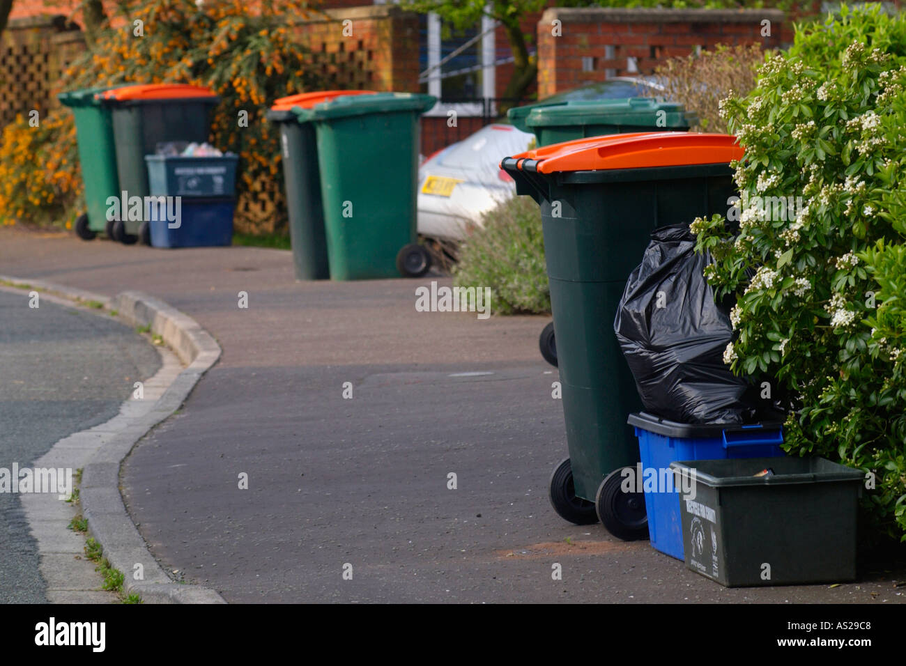 Boxes filled with material for recycling and wheelie bins full of domestic rubbish for landfill