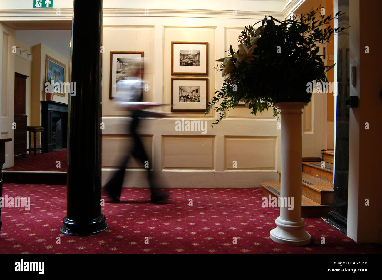 A waitress at wedding venue carries food along a corridor Stock Photo