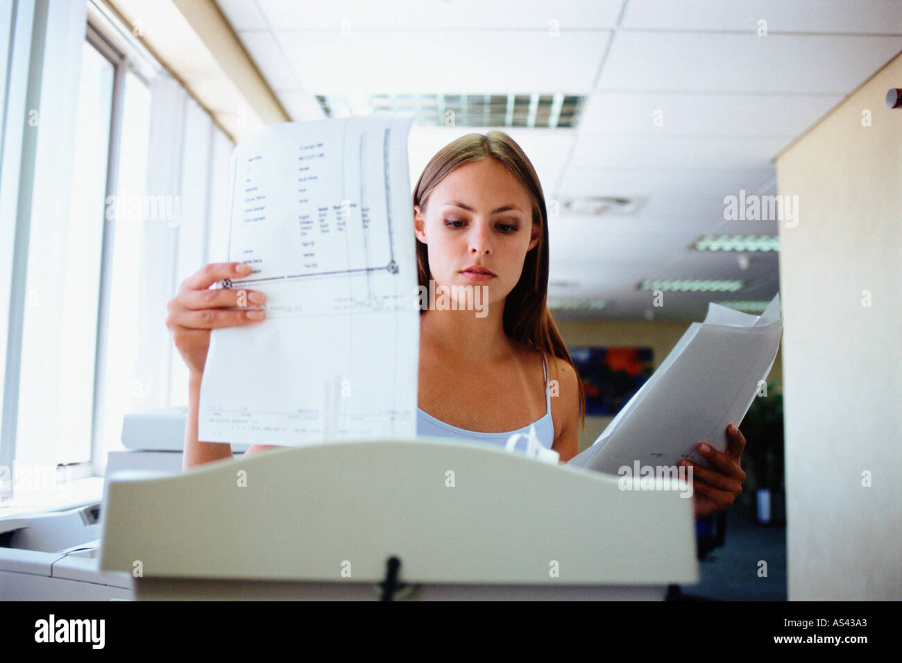 Woman about to shred paper Stock Photo