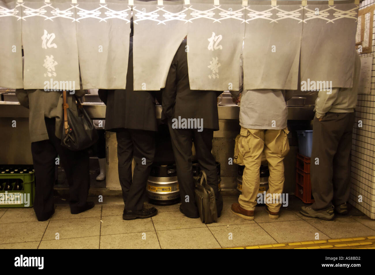 Workers have a drink after work in a bar in an Osaka railway station in