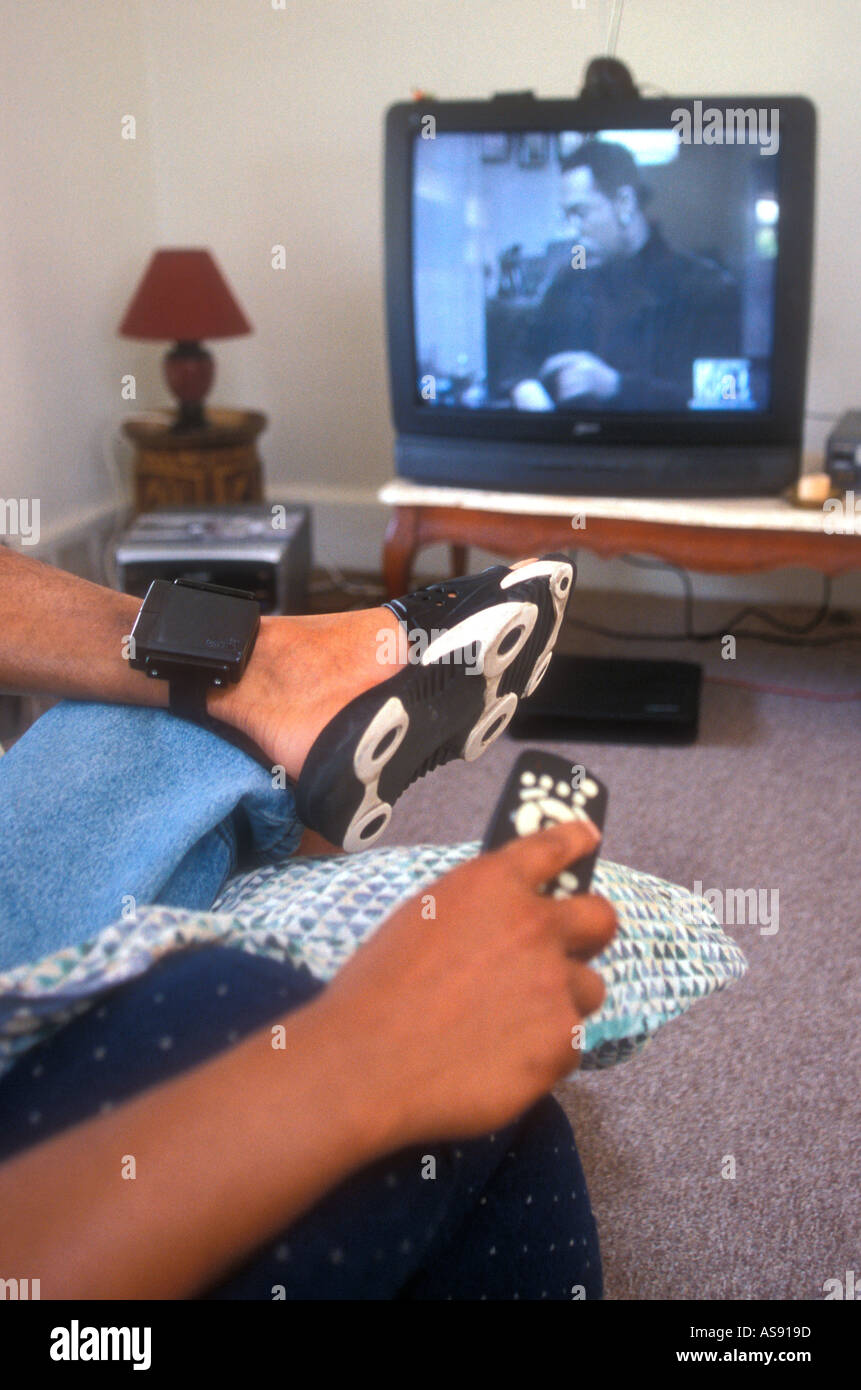 Prisoner on parole wears an electronic monitoring device on his ankle Stock Photo