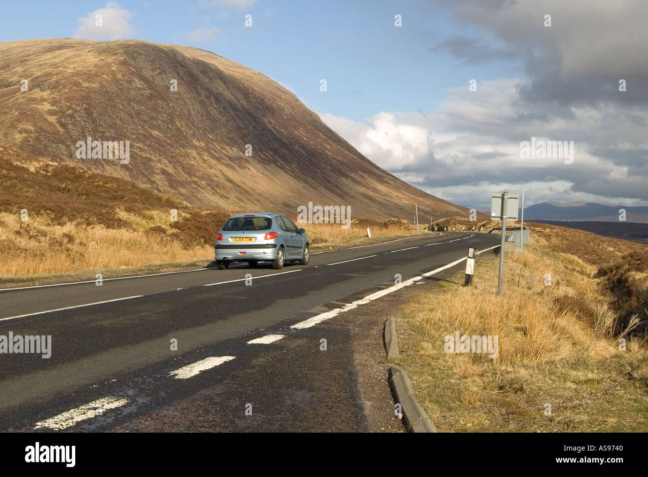 dh  GLENCOE ARGYLL Peugot silver car travelling down road mountains glen coe scotland highlands highland countryside drive scottish travel scenic a82 Stock Photo