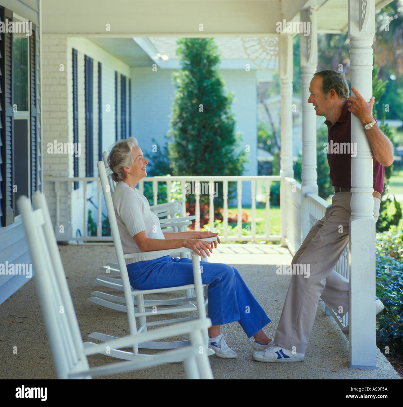 mature couple relaxing on rocking chairs on large porch Stock Photo - Alamy