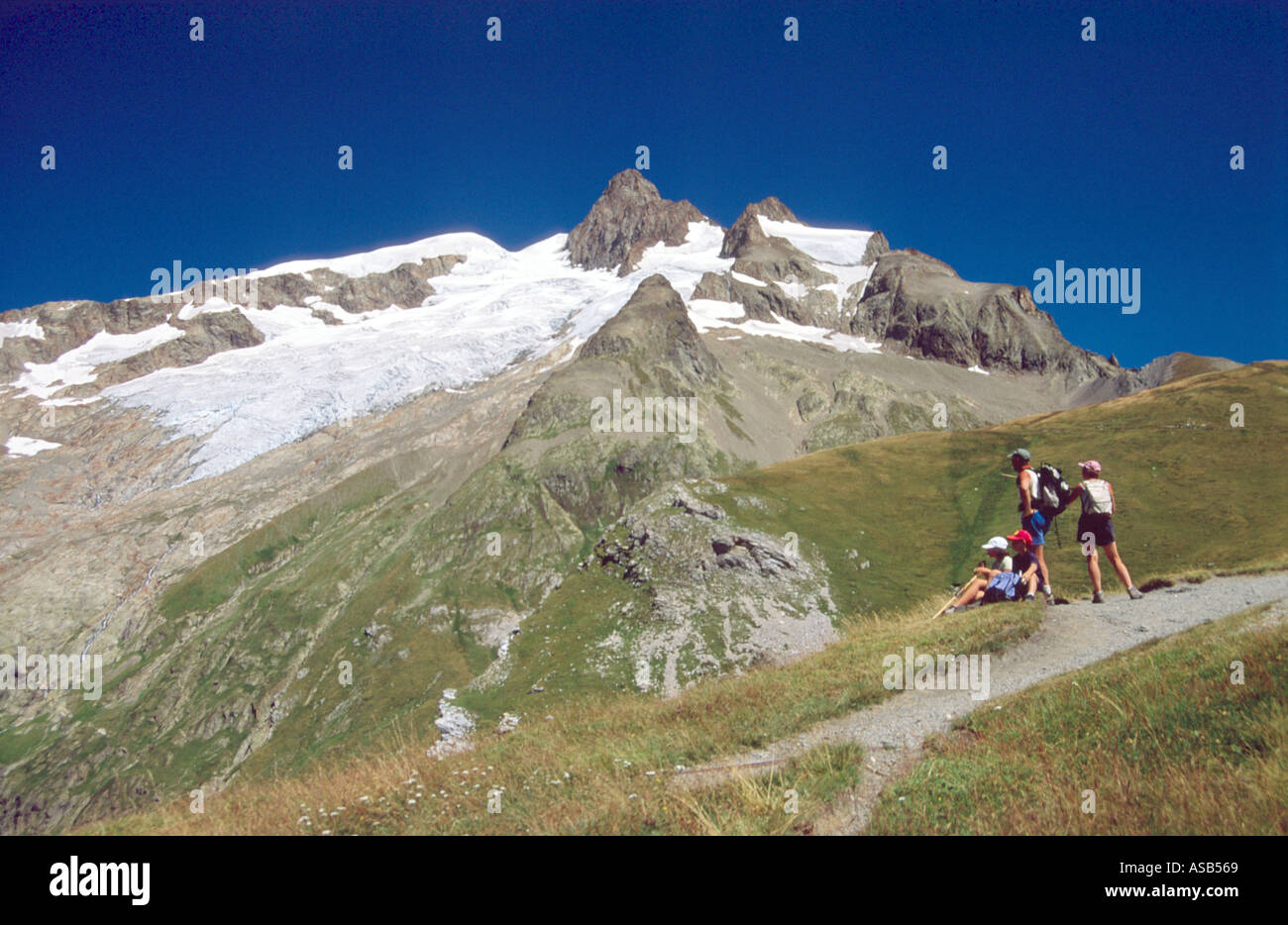 Family walking on the Tour of Mont Blanc below the Aiguille des Glaciers, French Alps, France Stock Photo