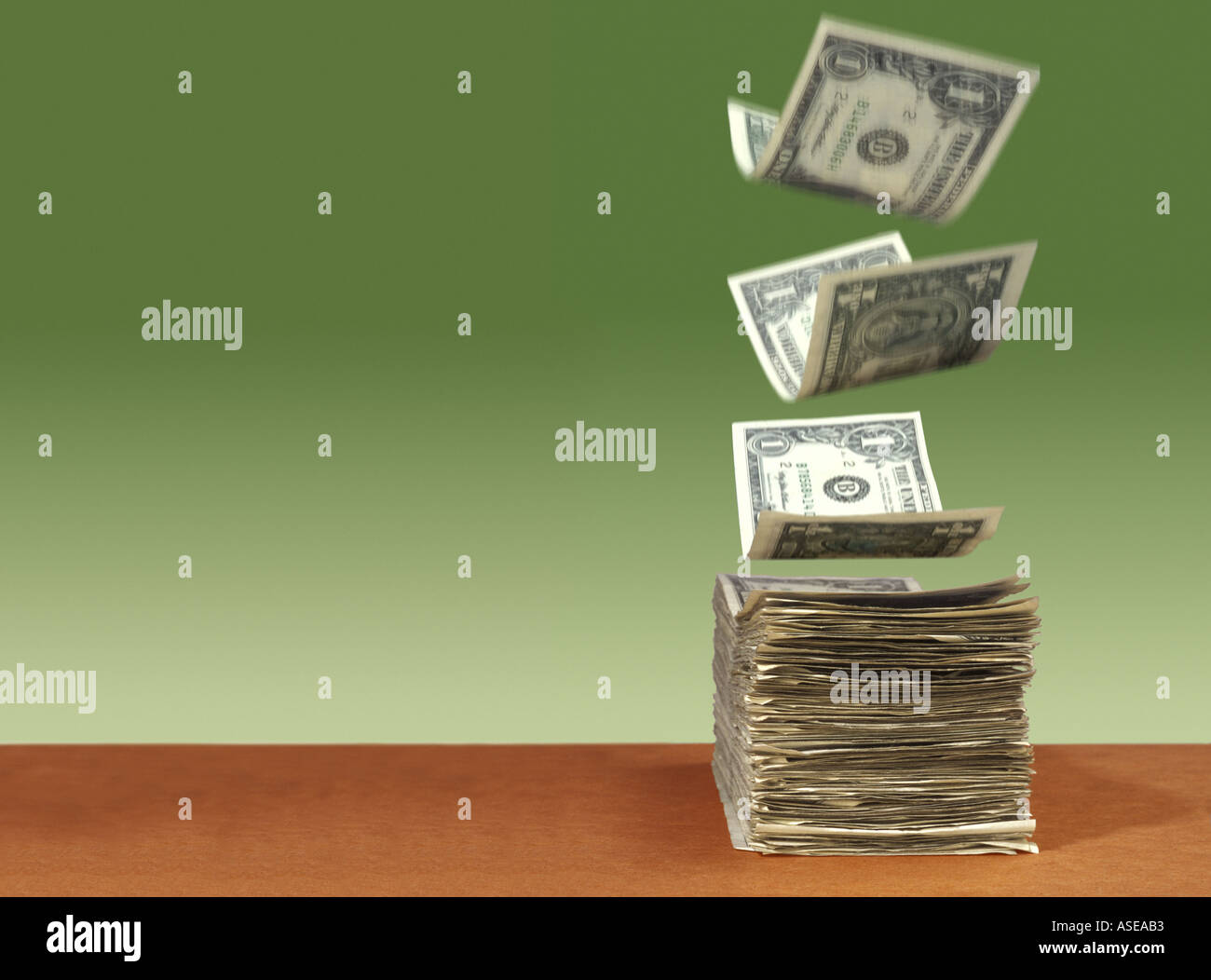 American 1 dollar bills float down and fall neatly into a thick stack ...