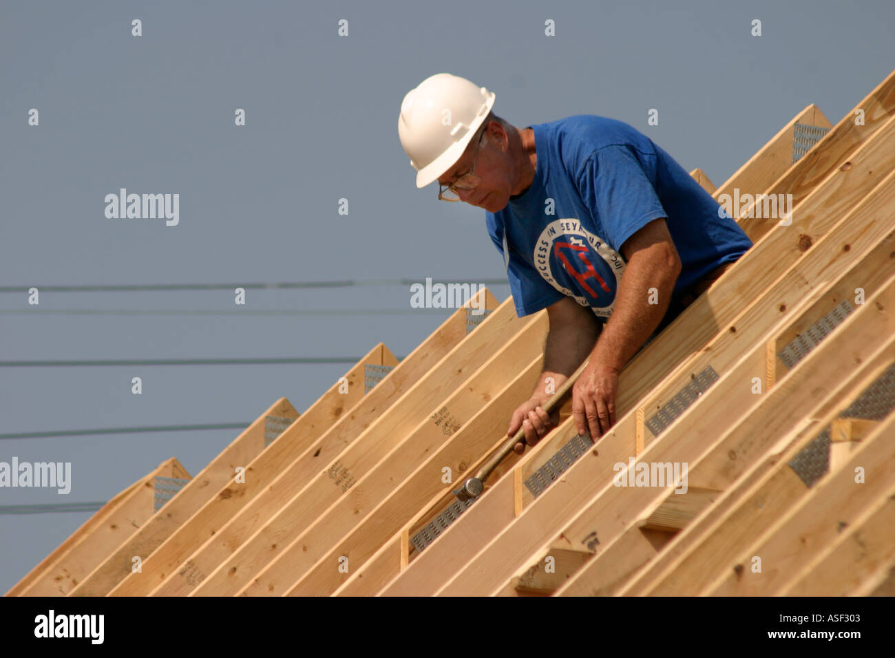 Volunteer helps build house for low family through Habitat for Humanity Stock Photo Alamy