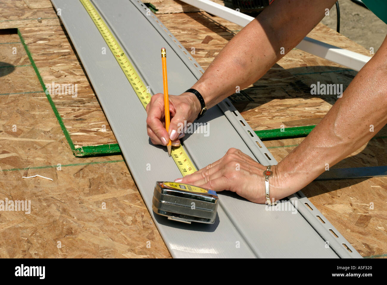 Volunteer helps build house for low income family through Habitat for Humanity Stock Photo
