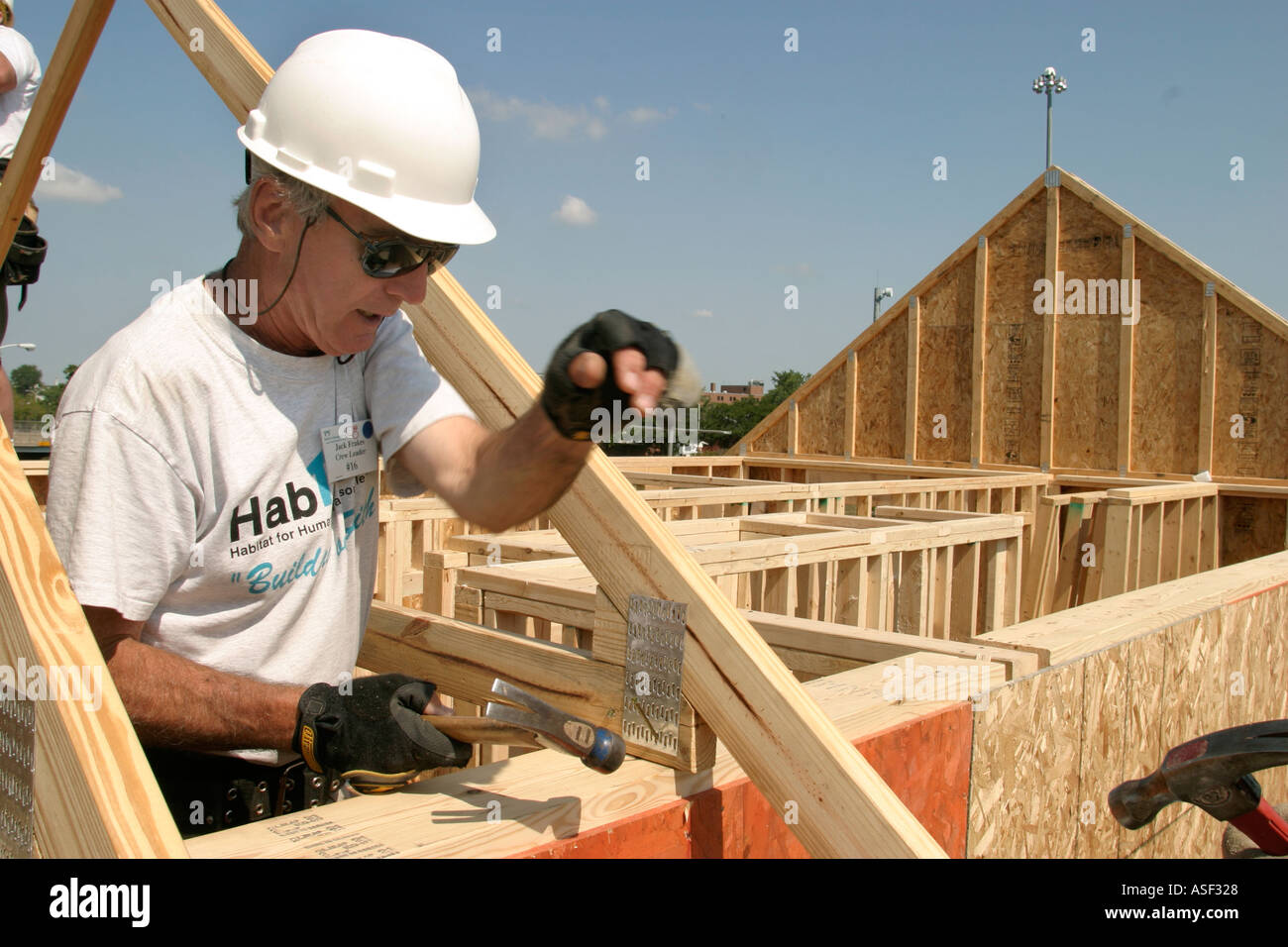 Volunteer helps build house for low family through Habitat for Humanity Stock Photo Alamy