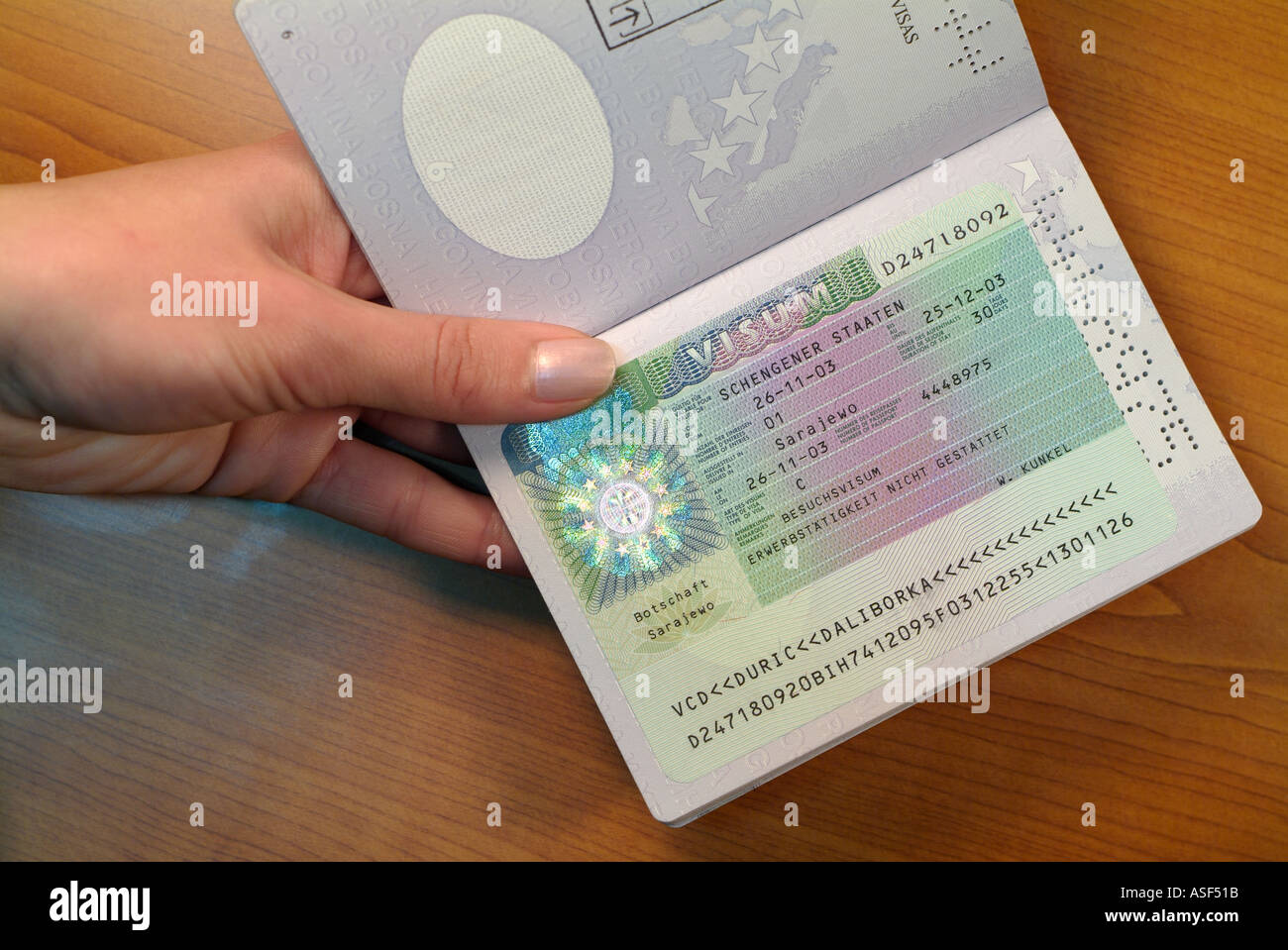 Eastern European Woman Passing over a Passport with a German Visa on the Page, Close Up. Stock Photo