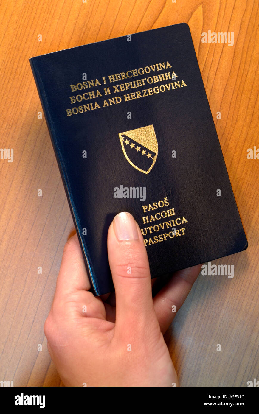 Womans Hand Passing Over a Bosnian Passport Stock Photo