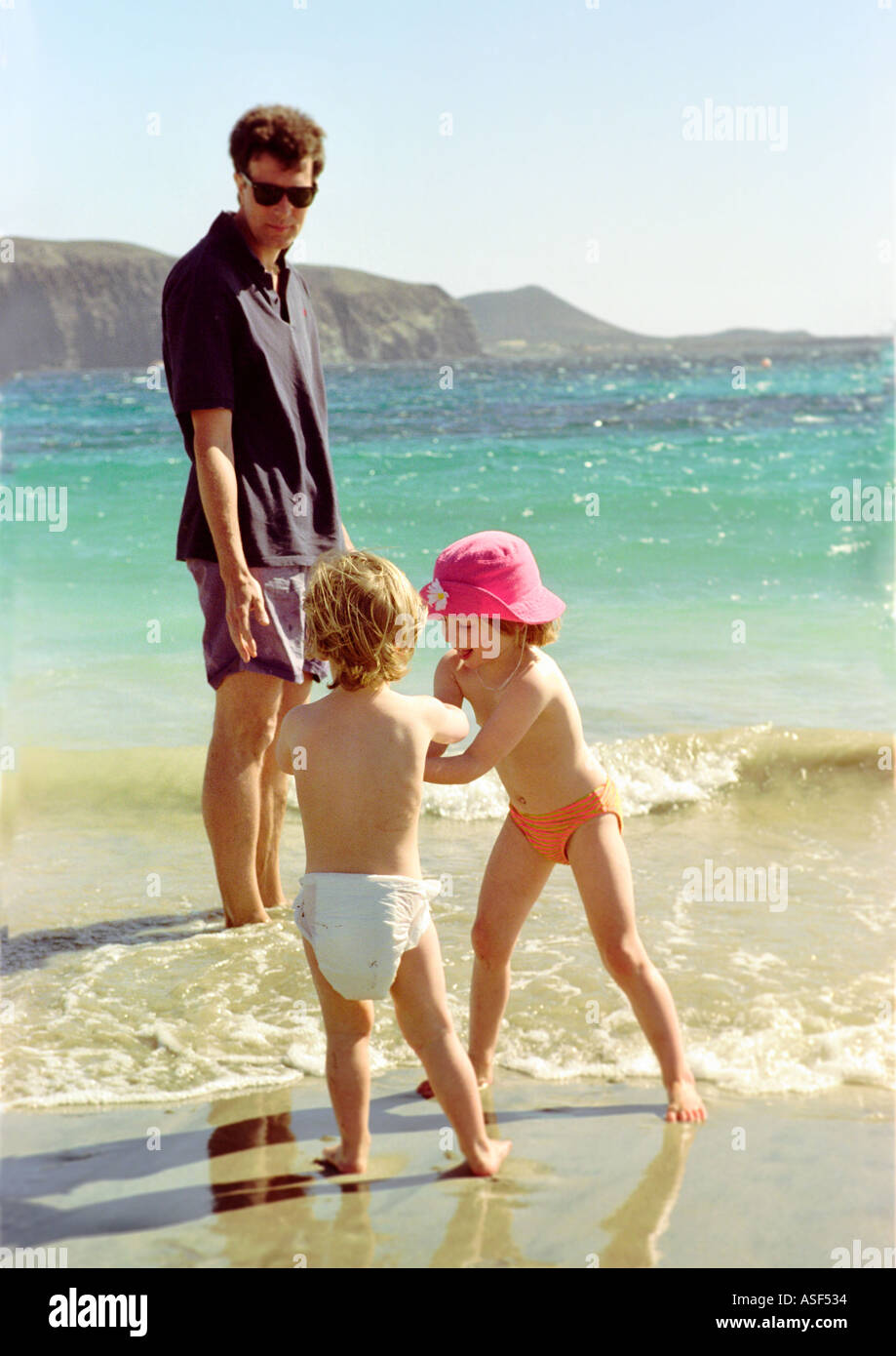 Father with children playing on the beach Stock Photo