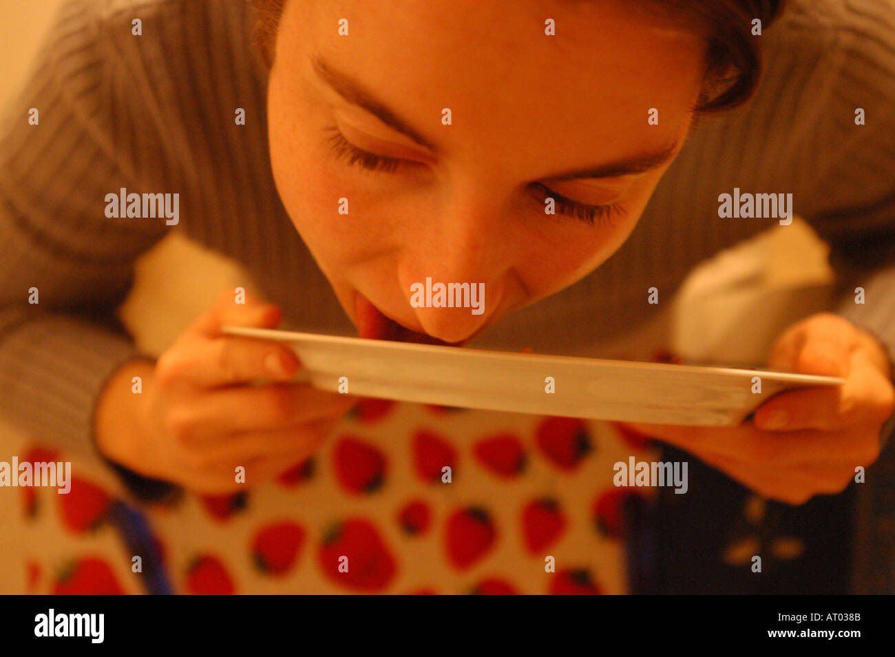 Young woman licking plate Stock Photo Alamy