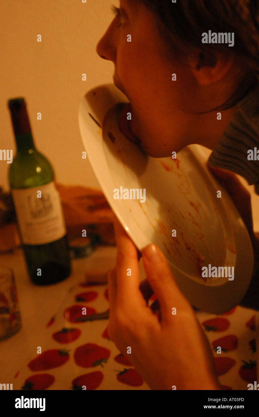 Young woman licking plate Stock Photo Alamy