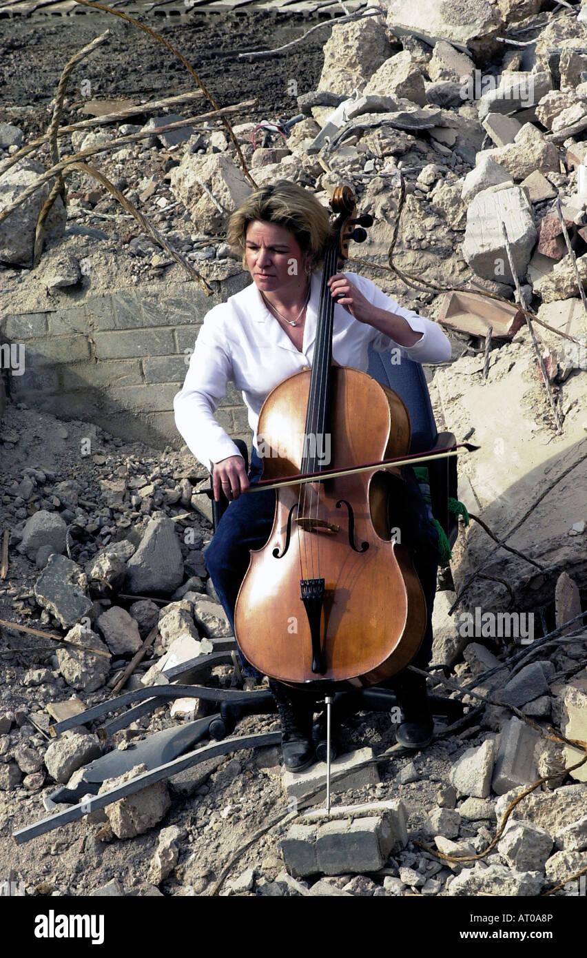 Woman playing cello on building site Stock Photo