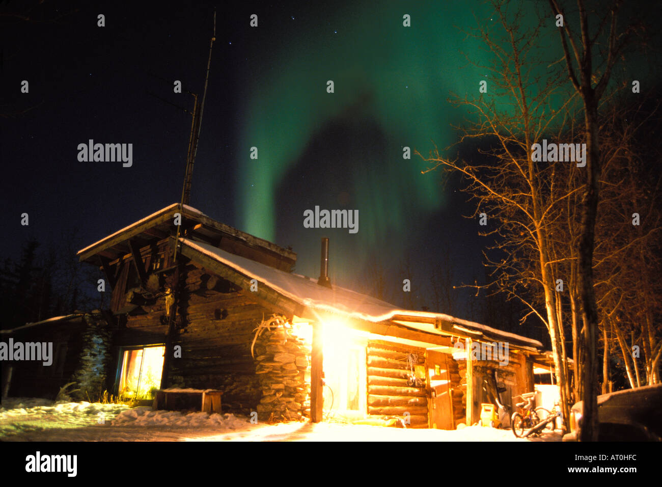 northern lights Aurora borealis over a cabin home in the village of ...