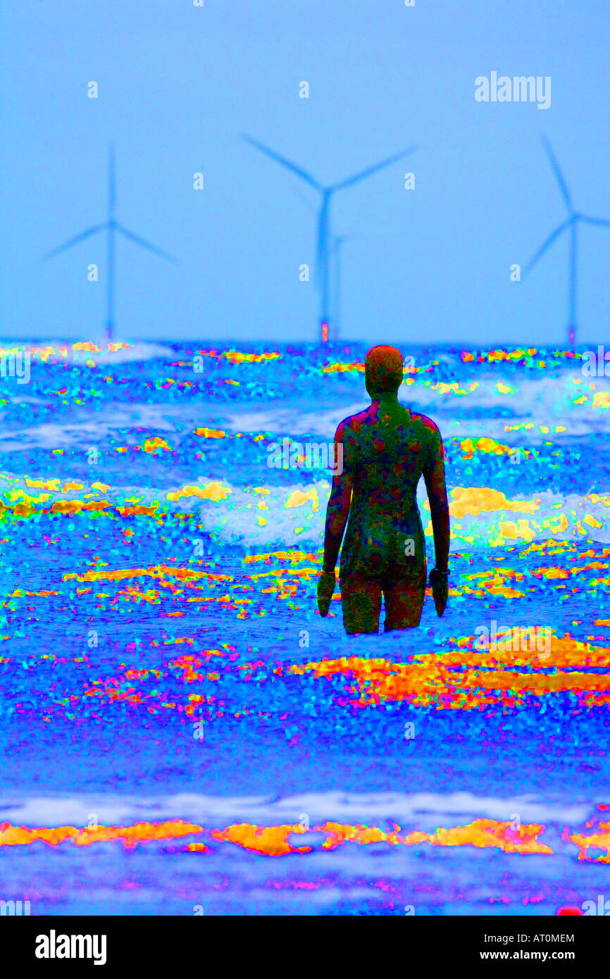 Another Place Antony Gormley sculpture of man looking out to sea towards wind power turbines Crosby Beach Merseyside England Stock Photo
