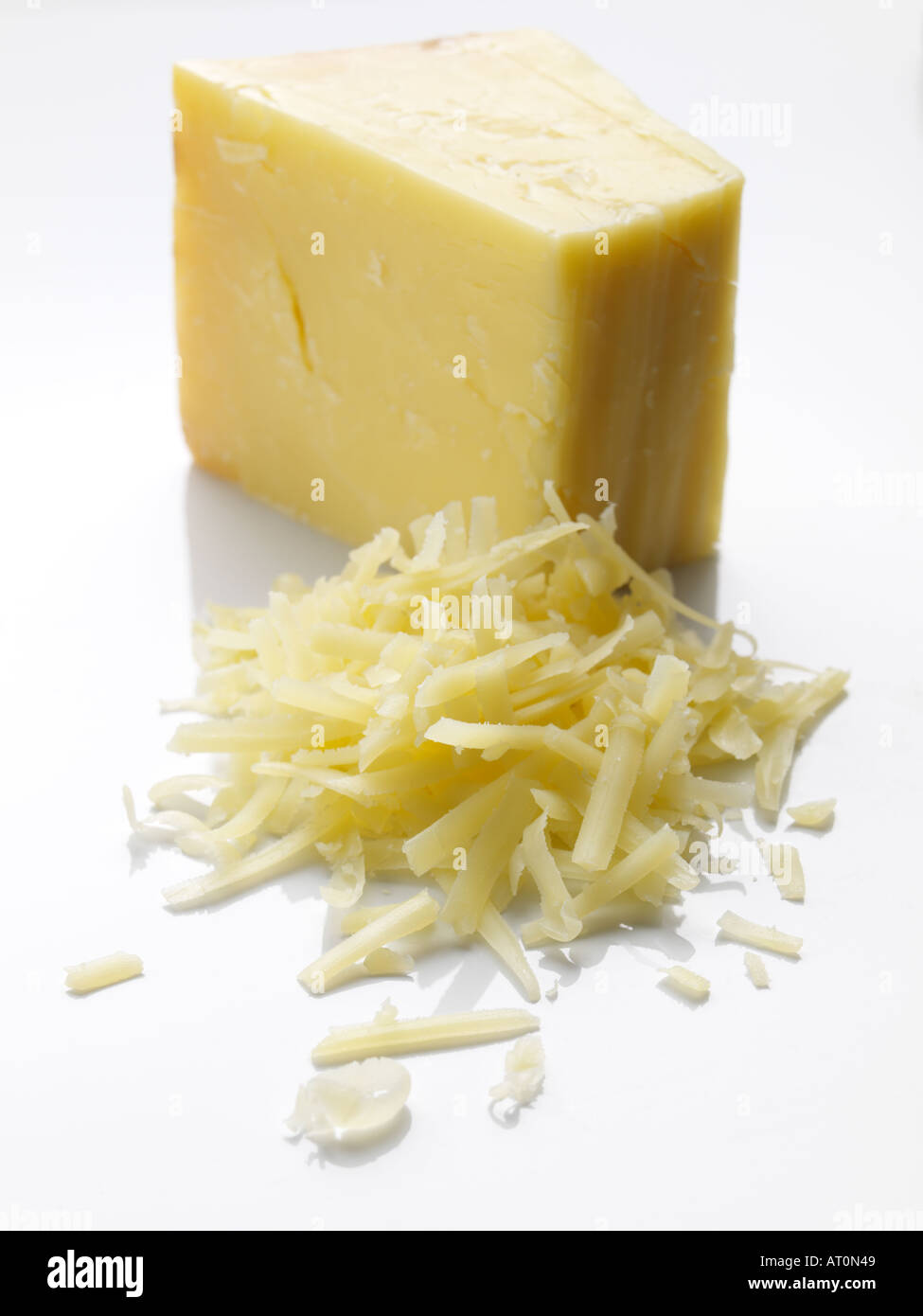 Grated and whole cheddar cheese Stock Photo Alamy