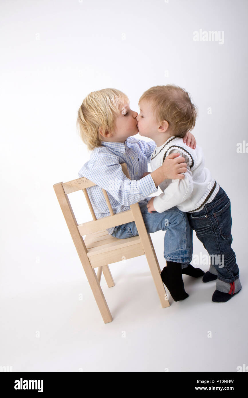 little boy on chair kissing little girl Stock Photo Alamy