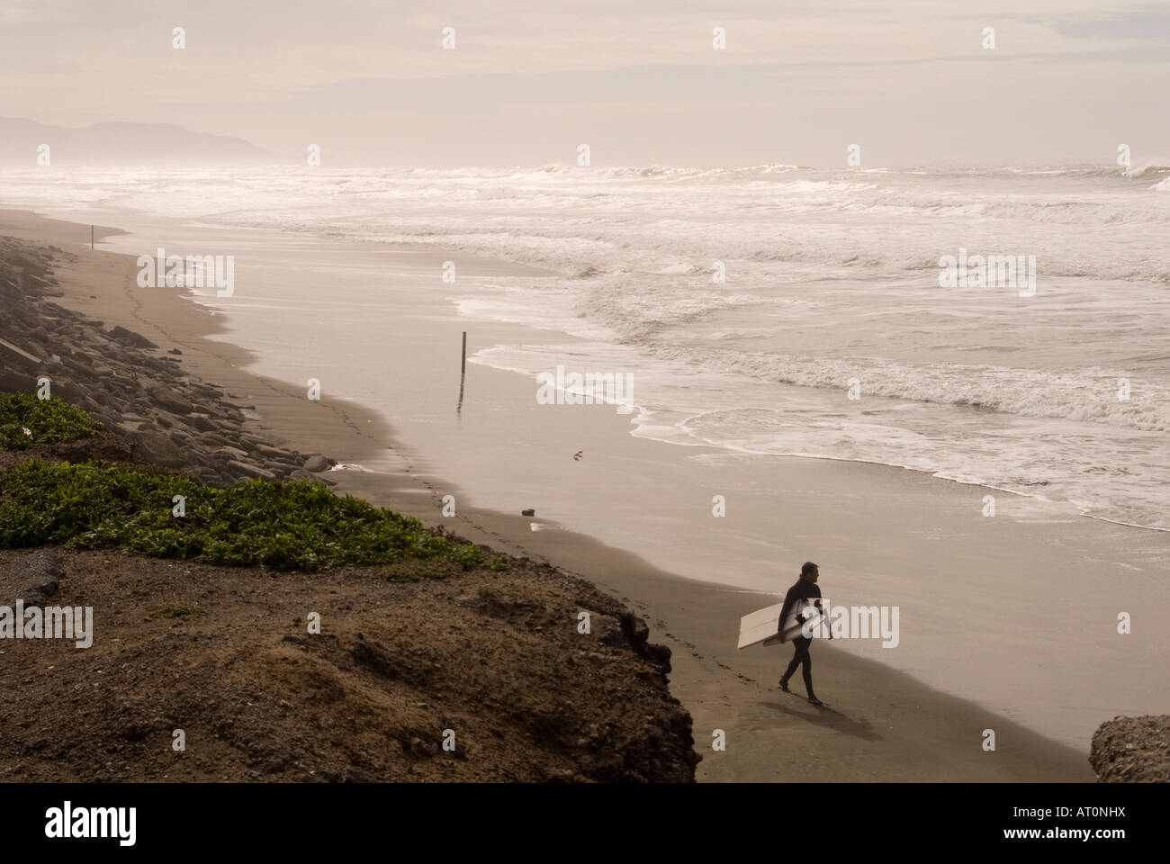 Surfer carries a broken surf board San Francisco California Stock Photo