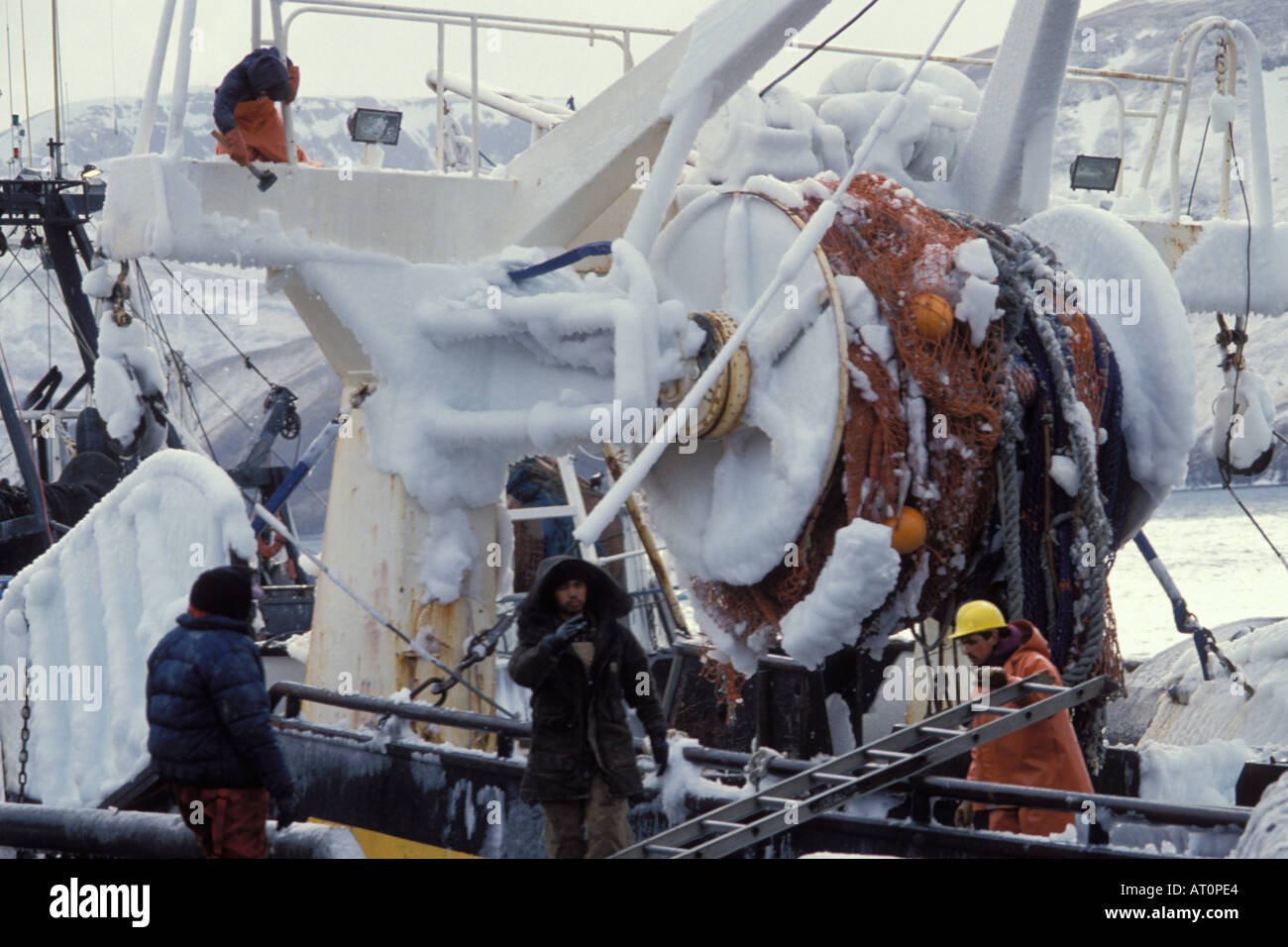 breaking ice off a commercial fishing vessel at dock in Akutan Alaska on the Aleutian Chain Bering Sea Stock Photo
