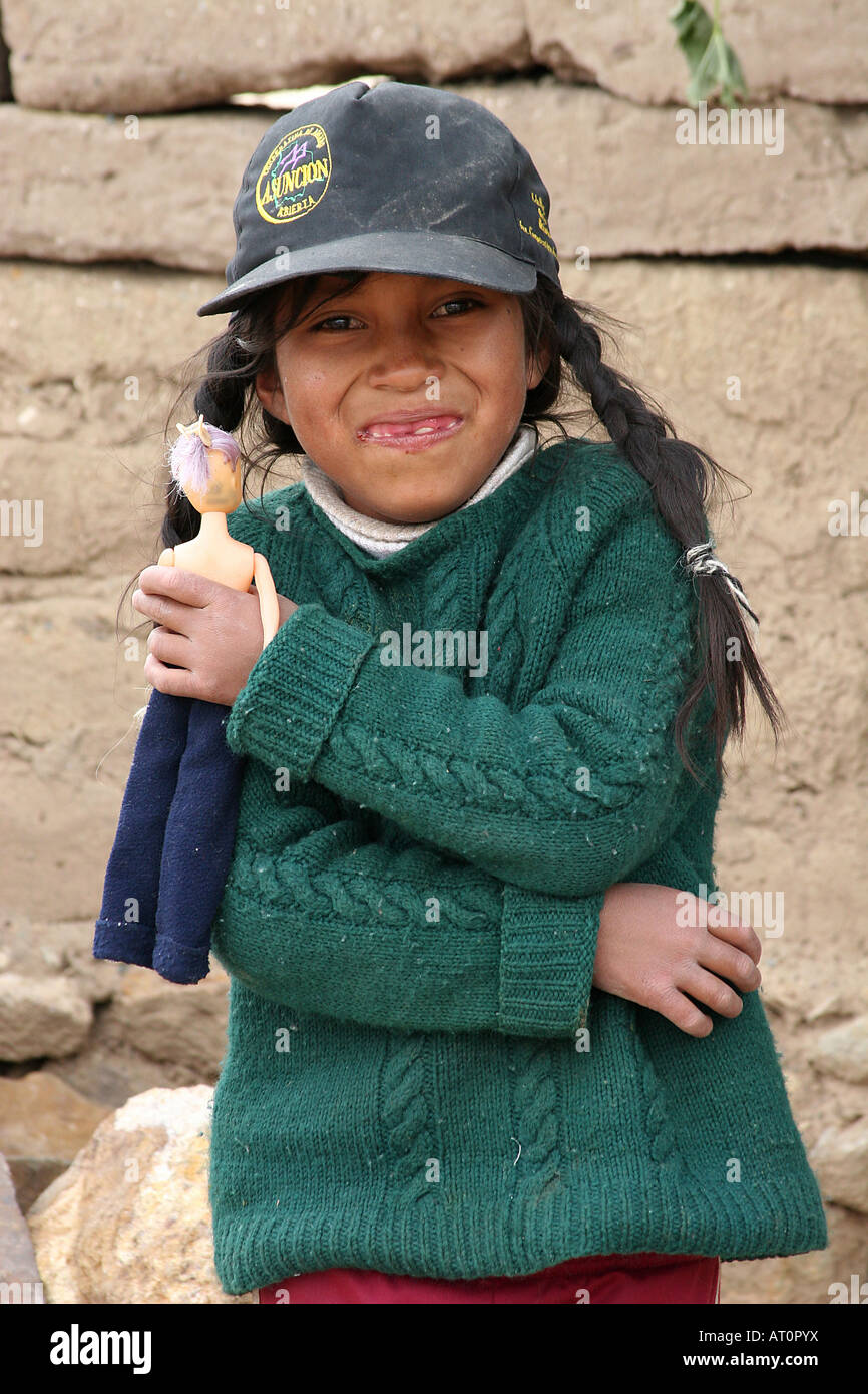 a portret of a girl holding a doll in Llaallagua, Potosi, bolivia, south america Stock Photo