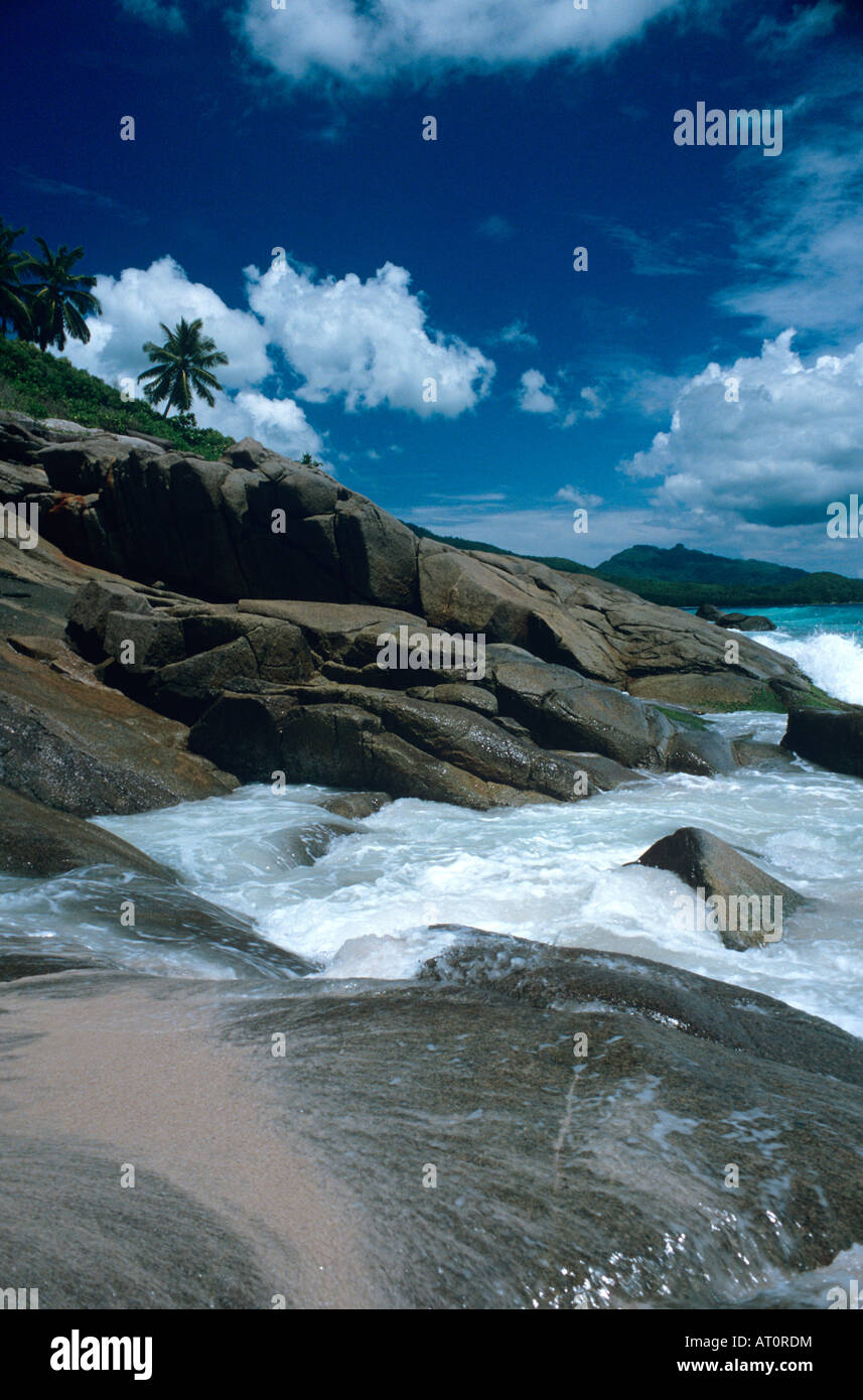 Waves breaking over rocks in the Seychelles Stock Photo