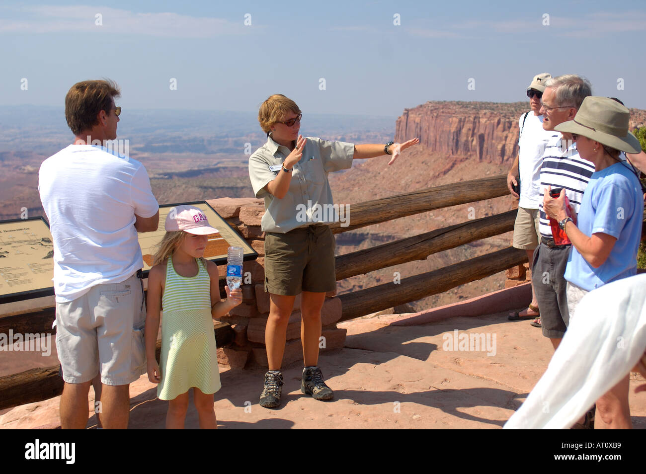 Park ranger discussing the formation of rock layers with tourists ...