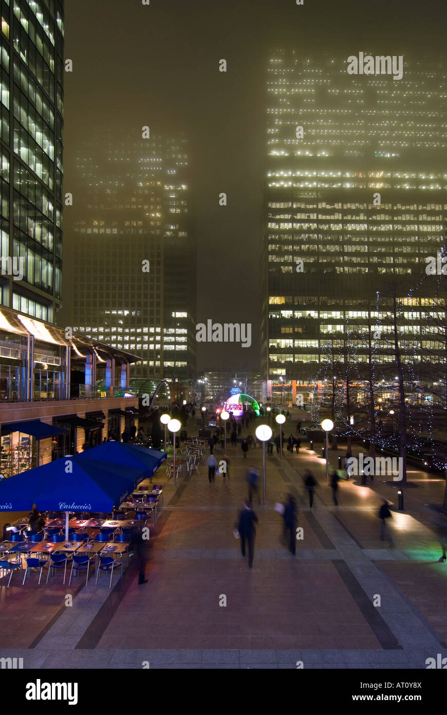 Vertical aerial wide angle of Reuters Place in Canary Wharf with commuters rushing home on a foggy winters night. Stock Photo