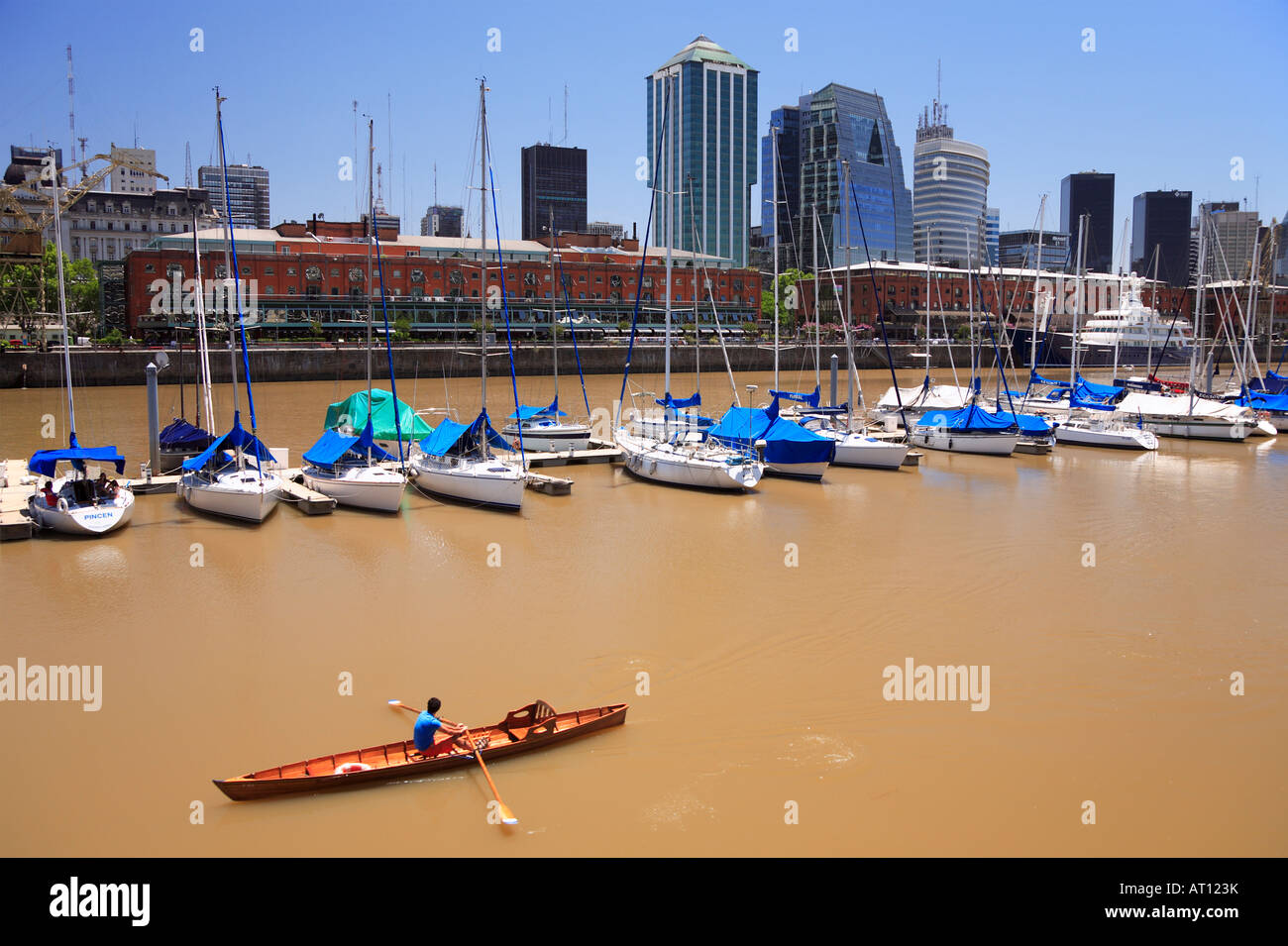 Row wood boat passing in front of yacht Club of Puerto Madero. Buenos Aires, Argentina Stock Photo