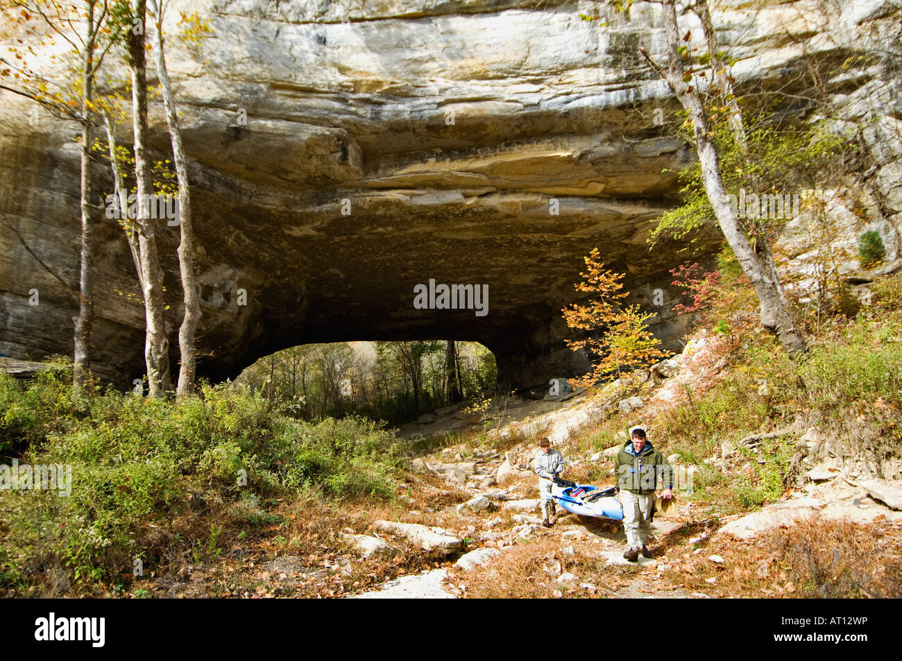Two Fishermen Carrying a Kayak through Rock House Natural Bridge to the