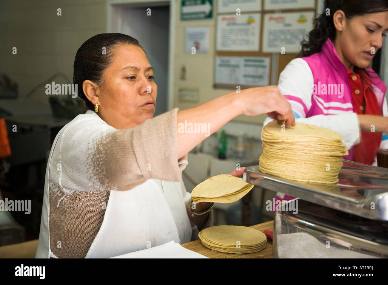 MEXICO Guanajuato Woman weigh stack of tortillas on scale in small tortilla making shop Stock Photo