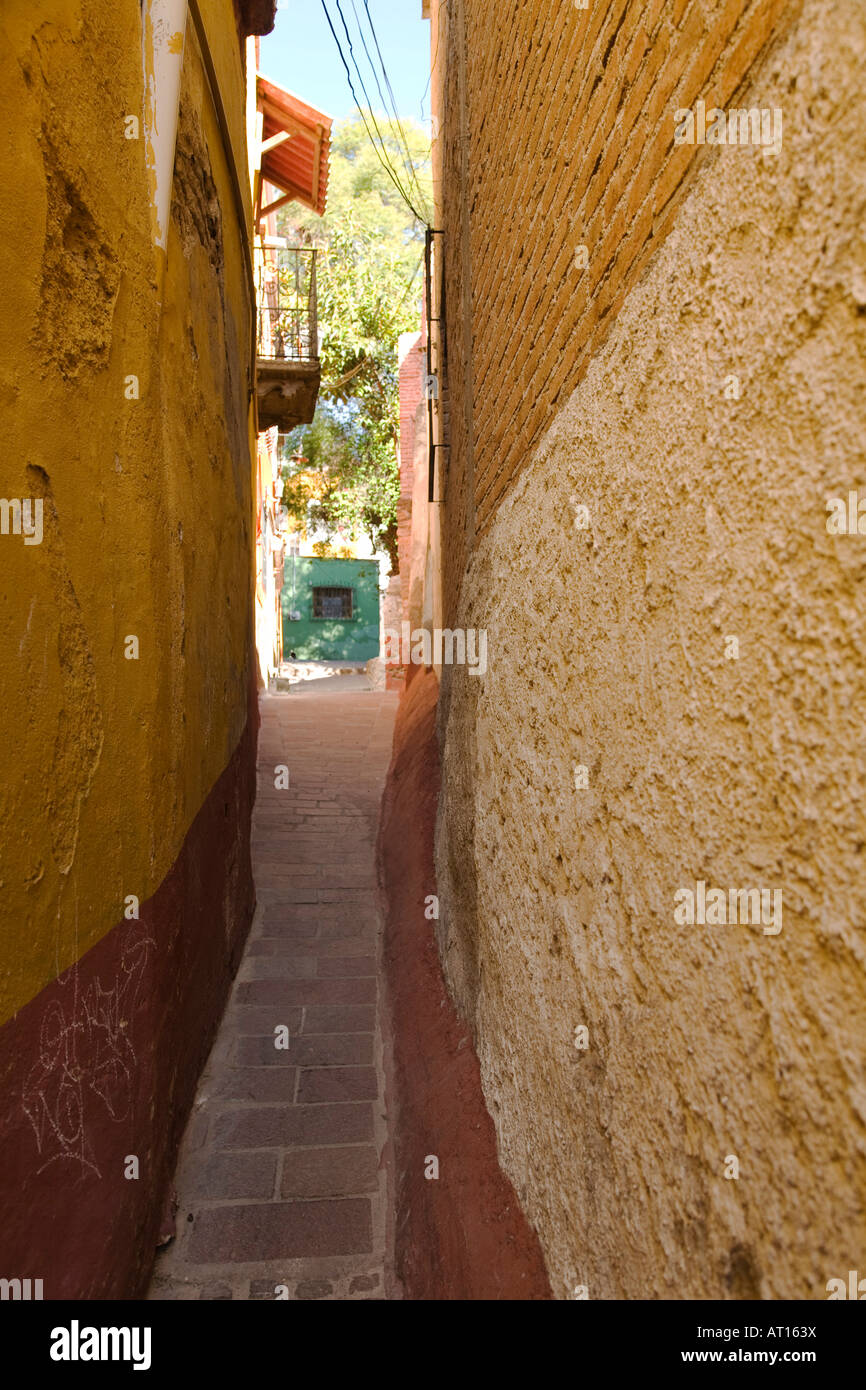 MEXICO Guanajuato Very narrow sidewalk going uphill passing between two buildings built close together Stock Photo