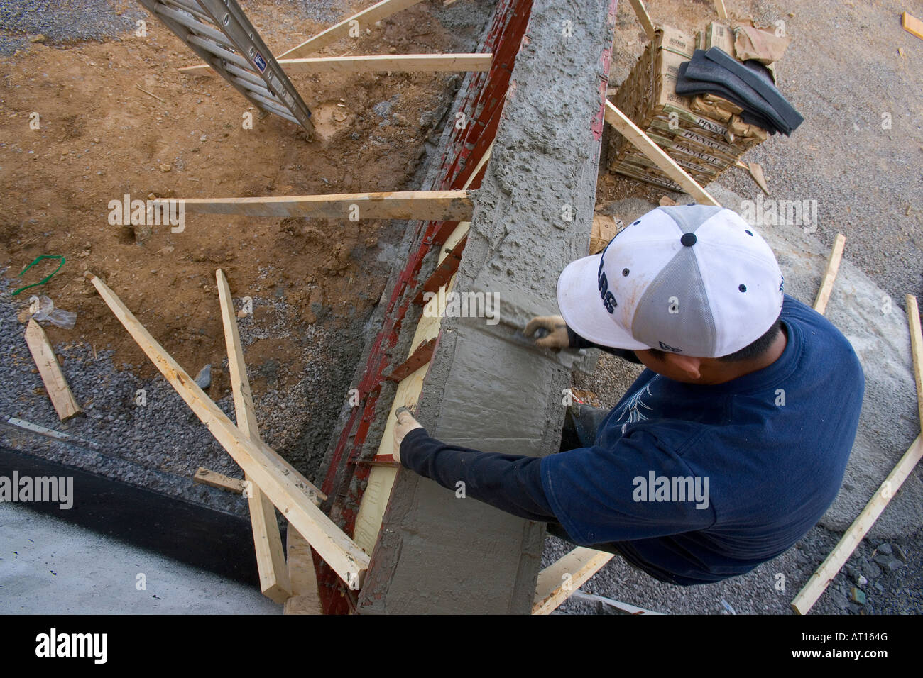 Worker building concrete retaining wall Stock Photo - Alamy