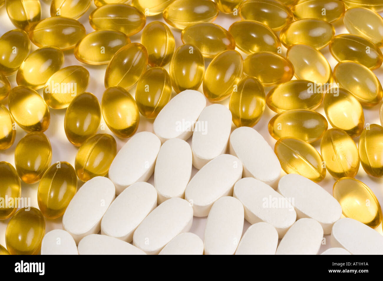 white Glucosamine and golden cod liver oil tablets many arranged in