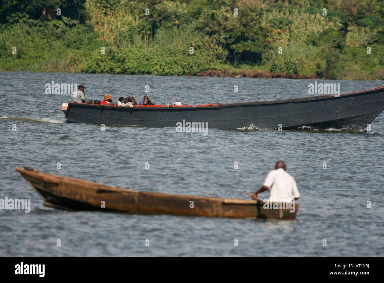 Two canoes, one motorised and one being paddled, pass each other on