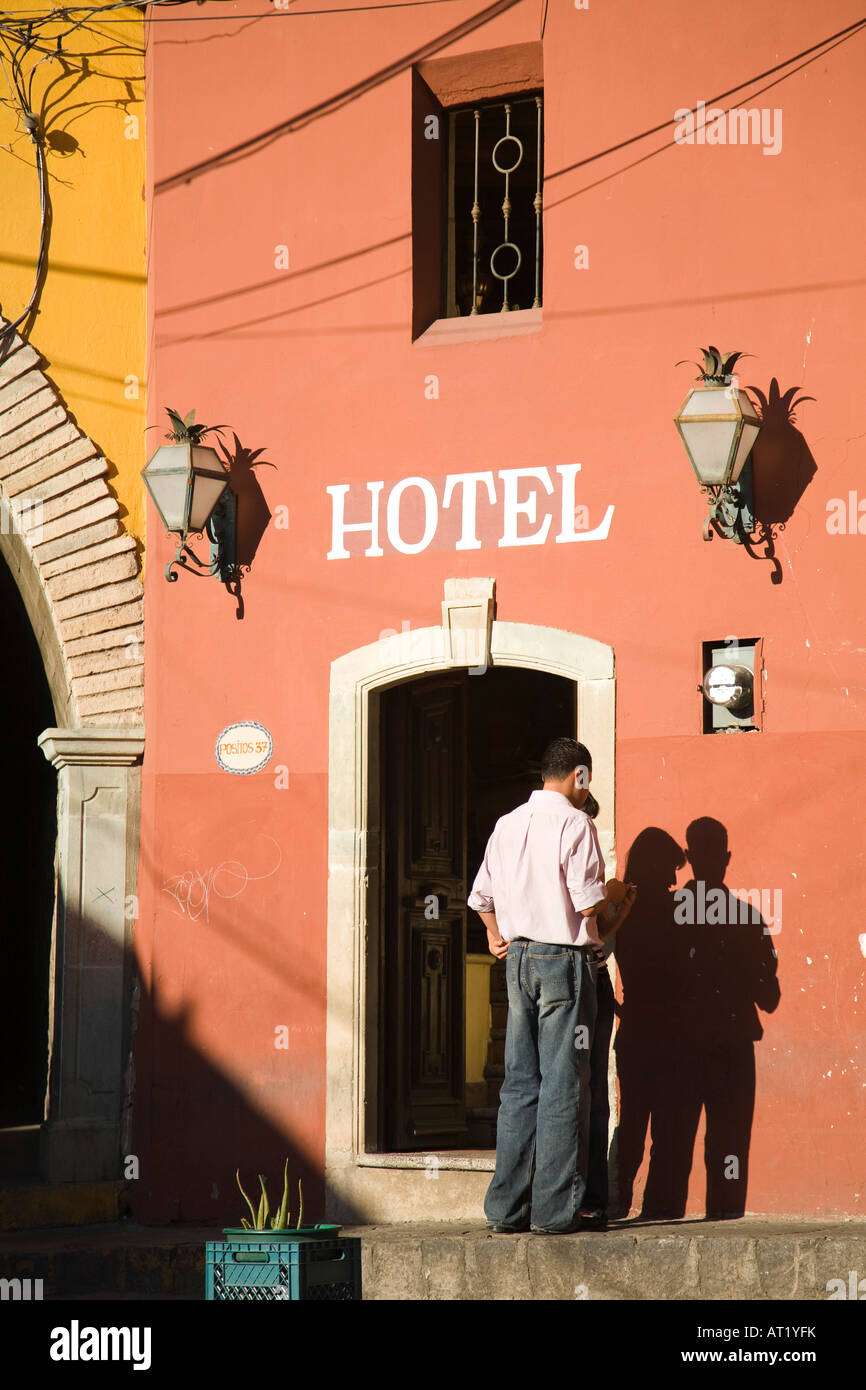 MEXICO Guanajuato Young couple standing outside doorway to hotel shadow on wall sign above entrance to building Stock Photo