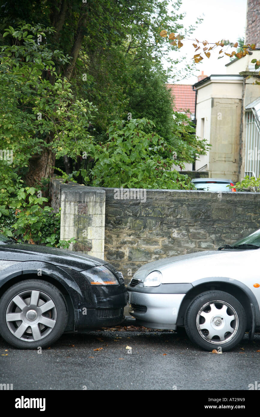 Two cars are parked litrally bumper to bumper so that their bumpers are