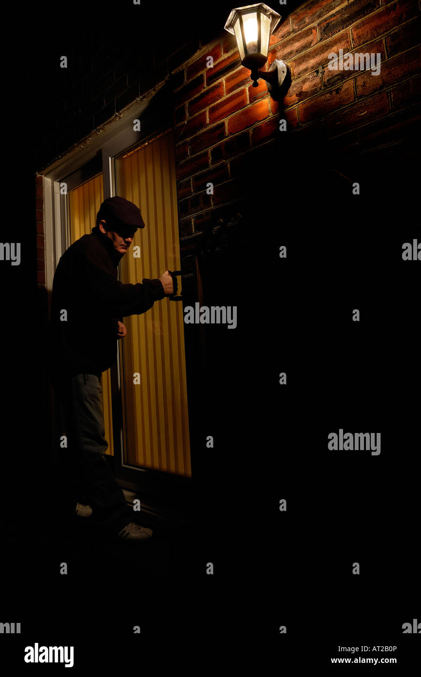 Man breaking into a house through the patio doors Stock Photo Alamy