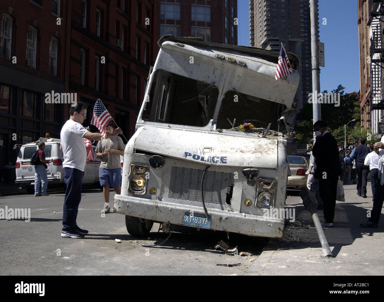 A man places a flag on a crushed police vehicle two days after 9 11 in New York City near ground zero Stock Photo