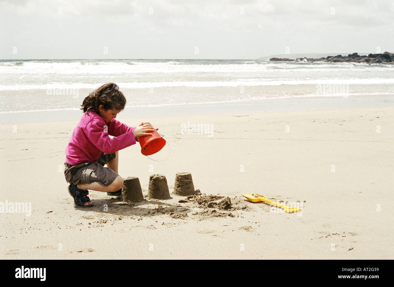 A girl building sand castles on the beach Stock Photo