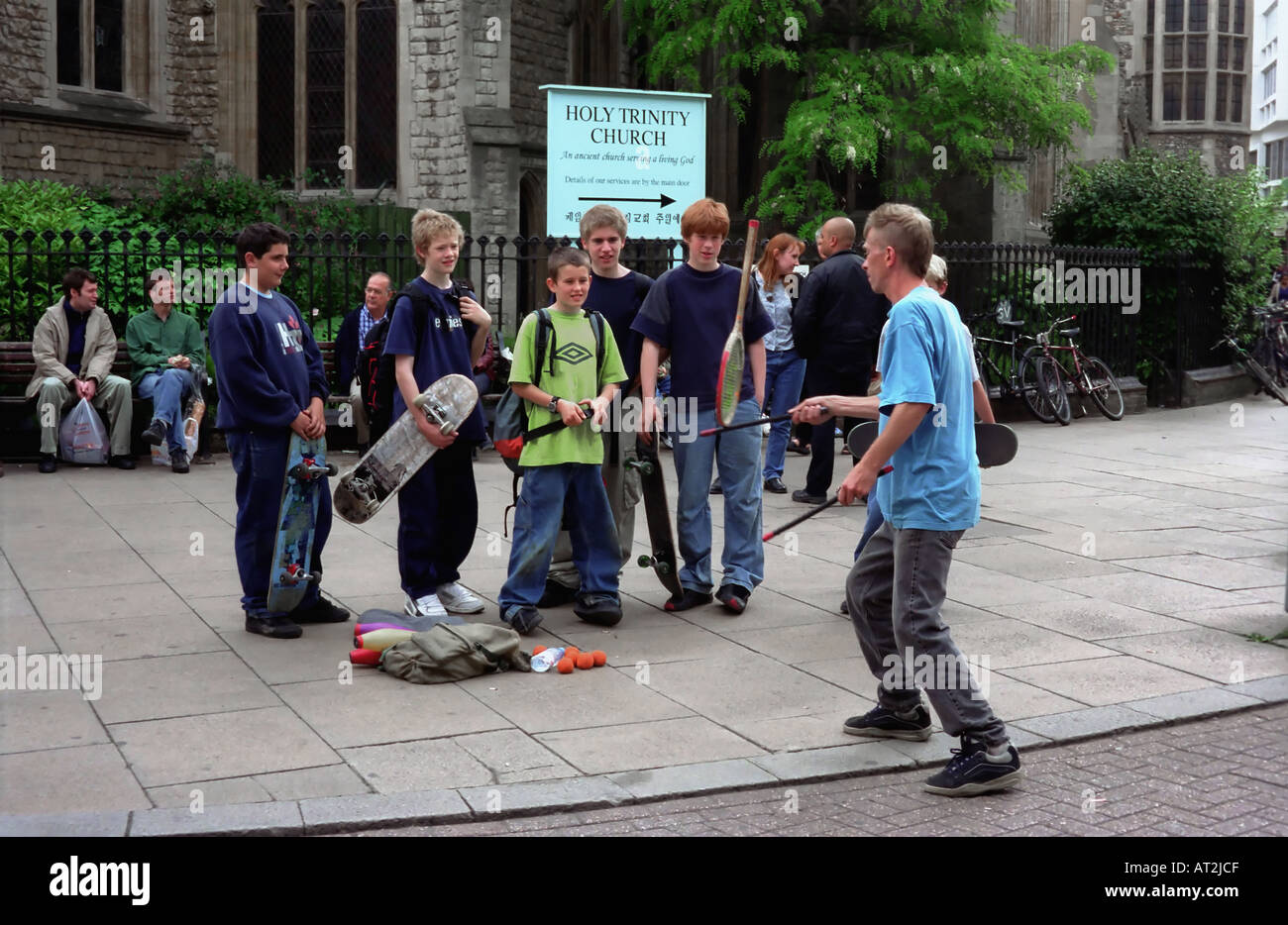 Boys watch a street entertainer balancing act in Cambridge England Stock Photo