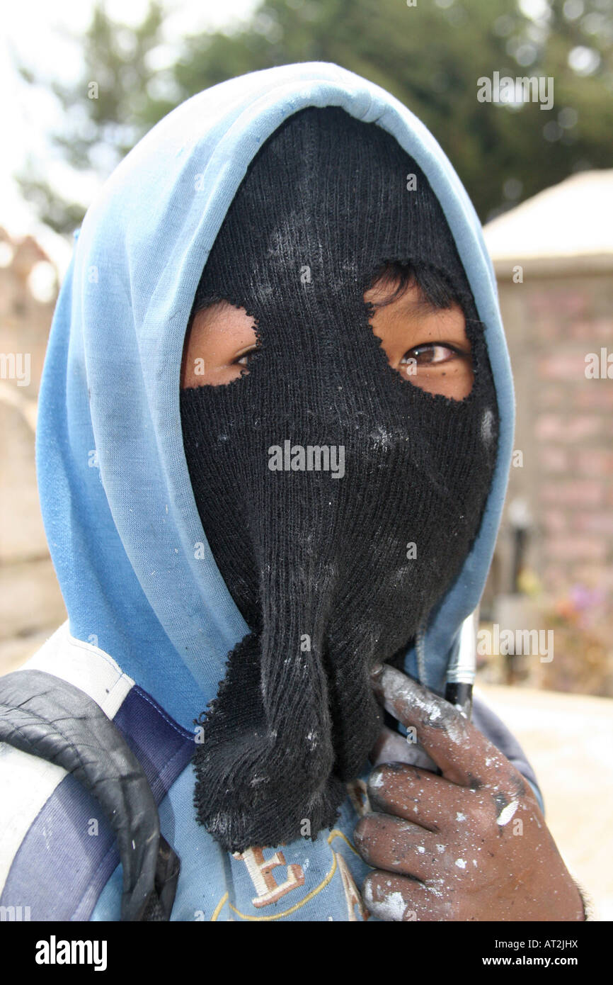 A young boy who work painting crosses wearing a balaclava to hide his face  at the cemetery in Llallagua, Potosi, bolivia Stock Photo - Alamy