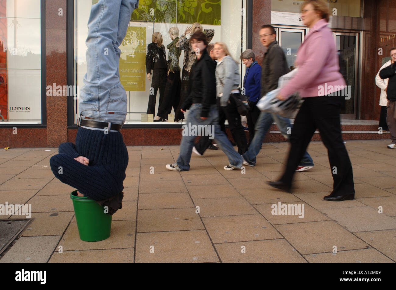 Man upside down with his head in a bucket outside Jenners on Princes Street, Edinburgh, Scotland Stock Photo