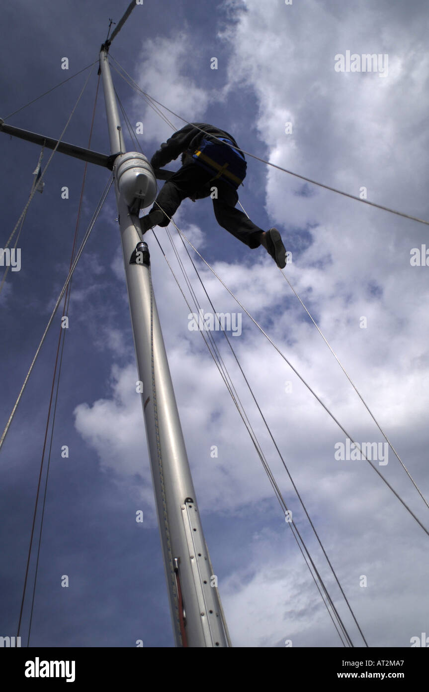 Climbing the mast of a 32' sailing yacht in a bosun's chair Stock Photo