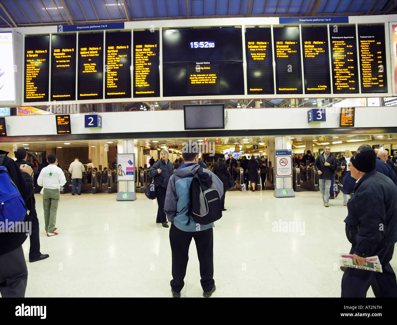 Commuters waiting on the Charing Cross mainline station concourse watch